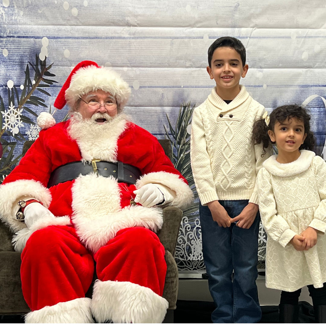 Santa Clause with two children posing for a photo