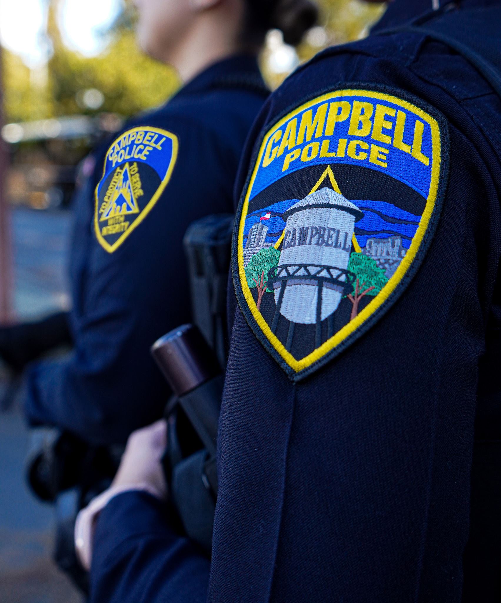 Two female Campbell Police officers. One wearing CPD's new patch and one wearing the retired patc