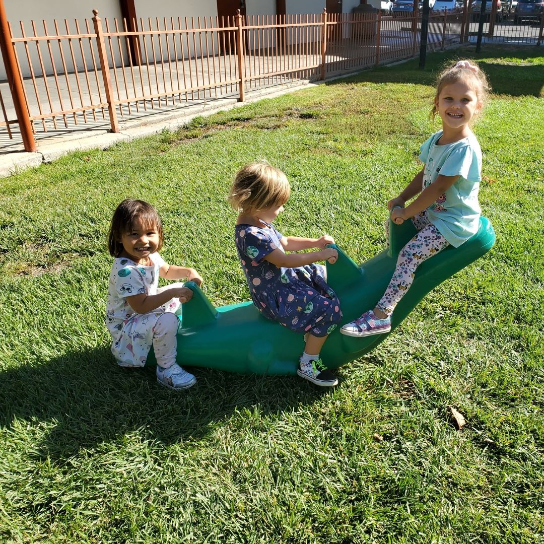 preschool students playing on a seesaw toy